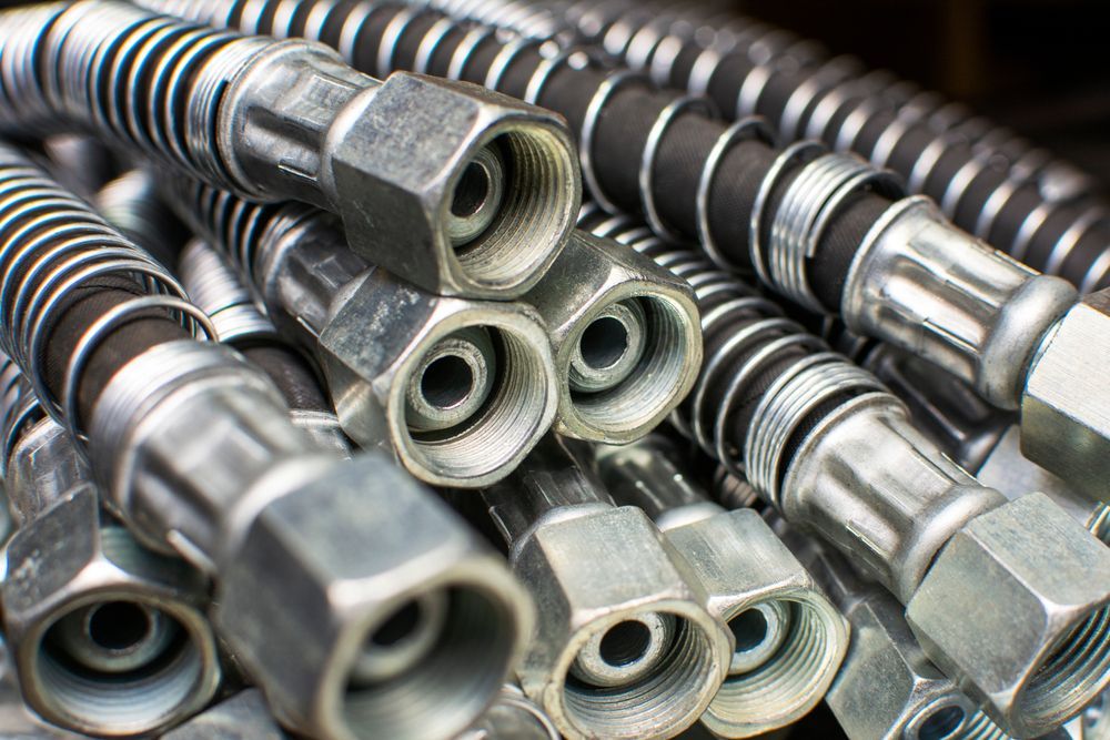 A Bunch of Hydraulic Hoses Are Stacked on Top of Each Other — Accredited Plumbing in Mollymook, NSW