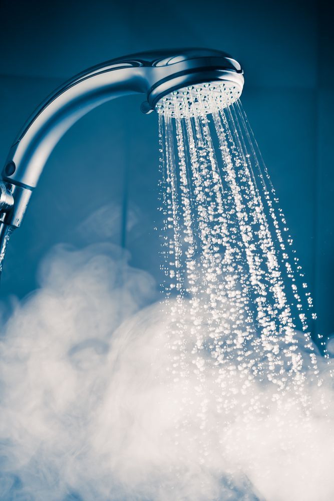 A Close Up of a Shower Head With Steam Coming Out of It — Accredited Plumbing in Narrawallee, NSW
