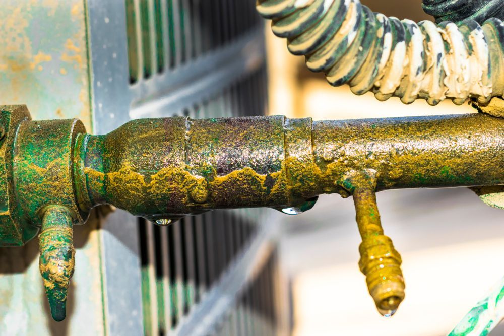 A Close Up of a Rusty Pipe With a Hose Attached to It — Accredited Plumbing in Lake Conjola, NSW