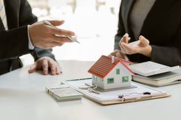 two people discussing real estate with a mini model home