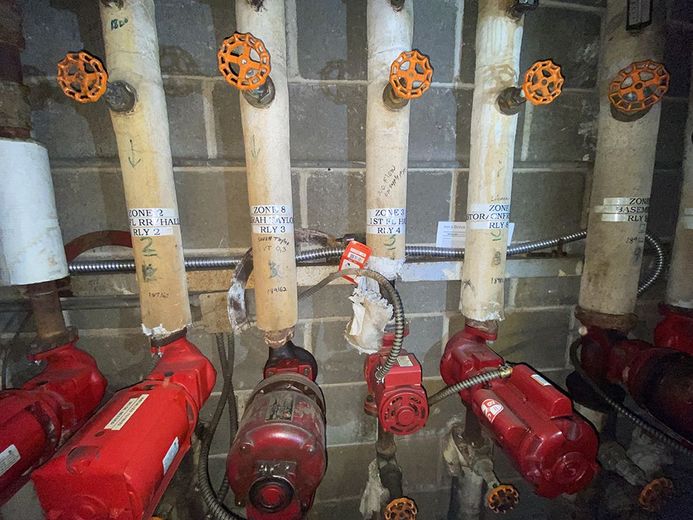 A bunch of pipes and valves are lined up in a room