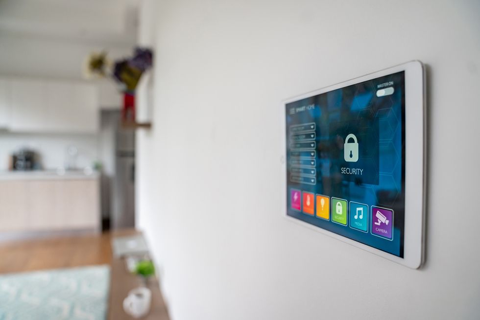A tablet is hanging on a wall in a living room.