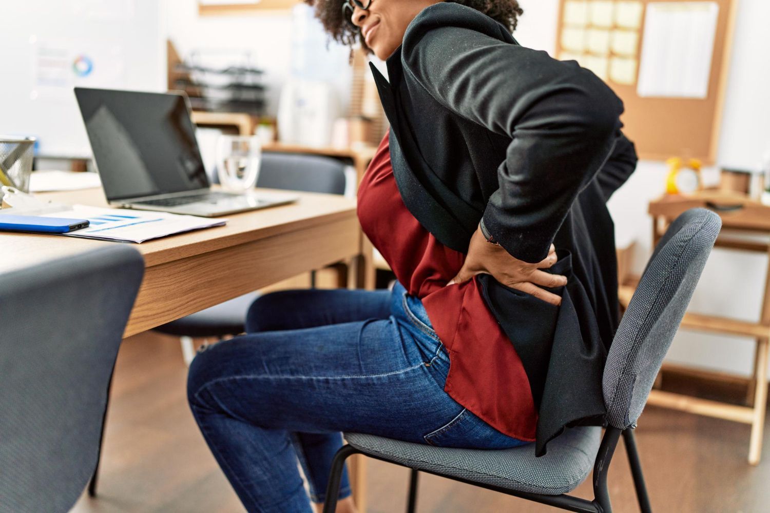 Physical therapist adjusting a patient’s back during treatment in a clinic room