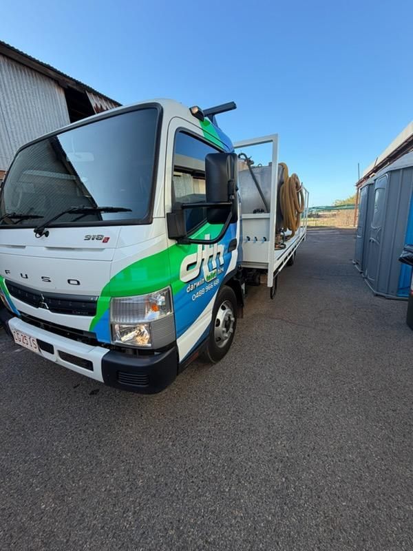 Green-and-white Cargo Truck Parked Beside a Blue Shipping Container — Darwin Toilet Hire in Palmerston, NT