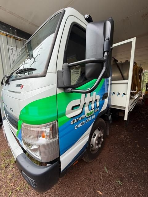 White and Green Cargo Truck With Open Side Door Parked Under a Covered Area — Darwin Toilet Hire in Rosebery, NT