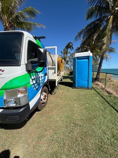 White and Green Truck Beside a Blue Portable Toilet — Darwin Toilet Hire in Palmerston, NT