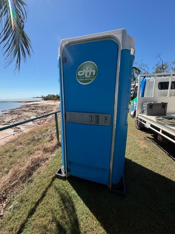 Blue Portable Toilet by a Beach, With Palm Trees and Parked Vehicle Nearby — Darwin Toilet Hire in Katherine, NT