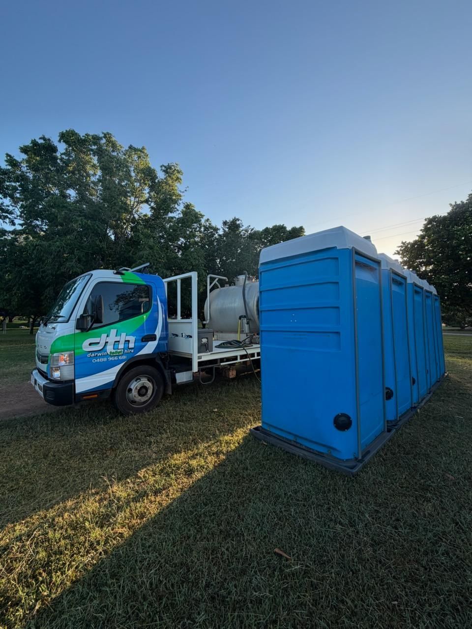 Blue Portable Toilet Beside a White Utility Truck — Darwin Toilet Hire in Rosebery, NT