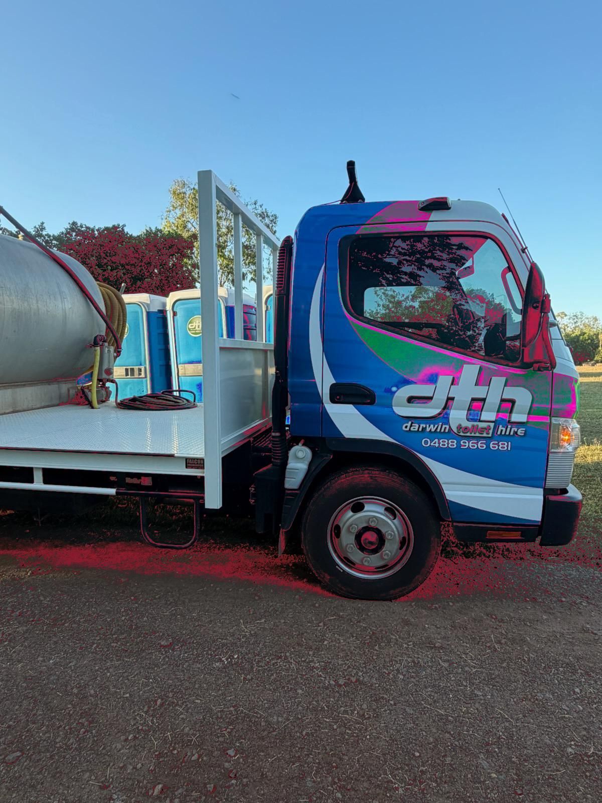 Blue and White Flatbed Truck With a Large Tank Parked Outdoors — Darwin Toilet Hire in Rosebery, NT