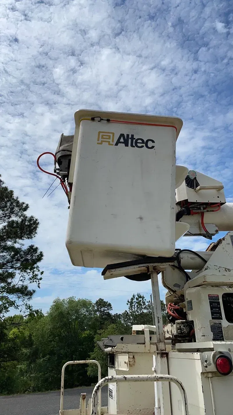 A white bucket truck with a blue sky in the background.
