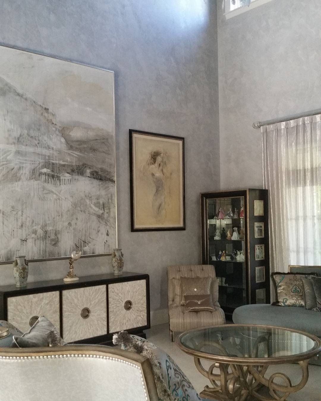 Elegant living room with art, furniture, and textured gray walls.