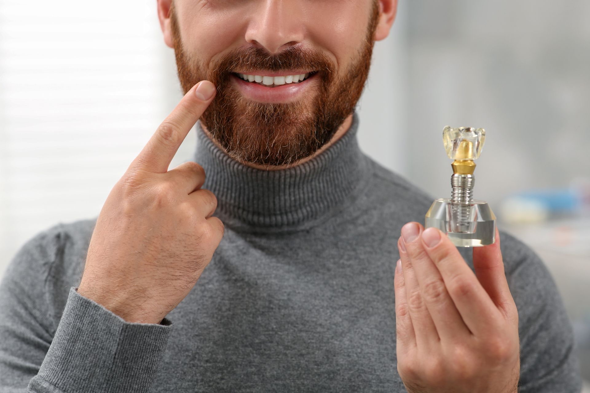 Close-up of a patient holding a model of dental implants to show successful tooth restoration.
