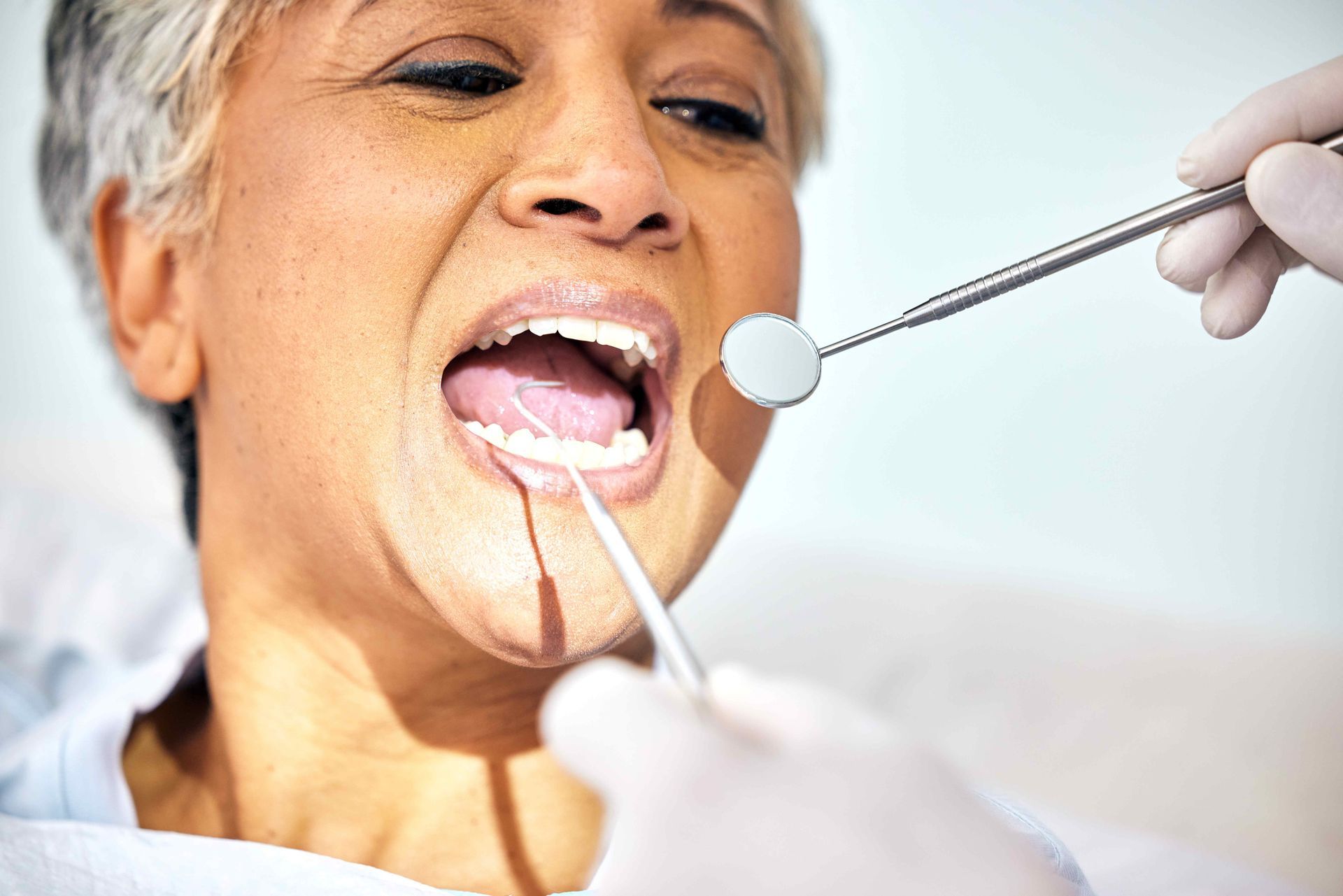 Senior woman, mouth and dentist check teeth, metal tools and hands with healthcare, toothache and dental surgery Senior woman, mouth and dentist check teeth, metal tools and hands with healthcare, toothache and dental surgery