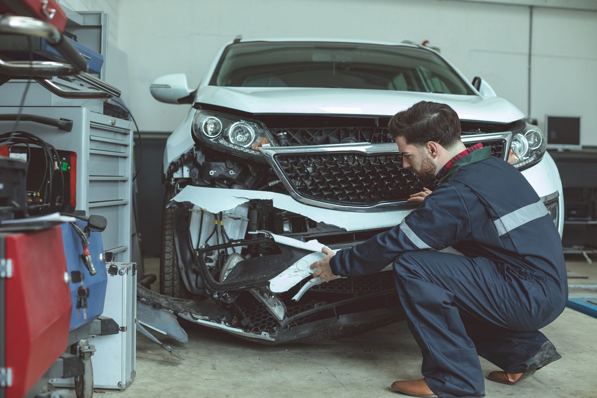 Auto Mechanic Checking Car Battery Voltage — Chula Vista, CA — Bonita Point Auto Care 76 Mechanic performing car repair on a vehicle in a service bay.