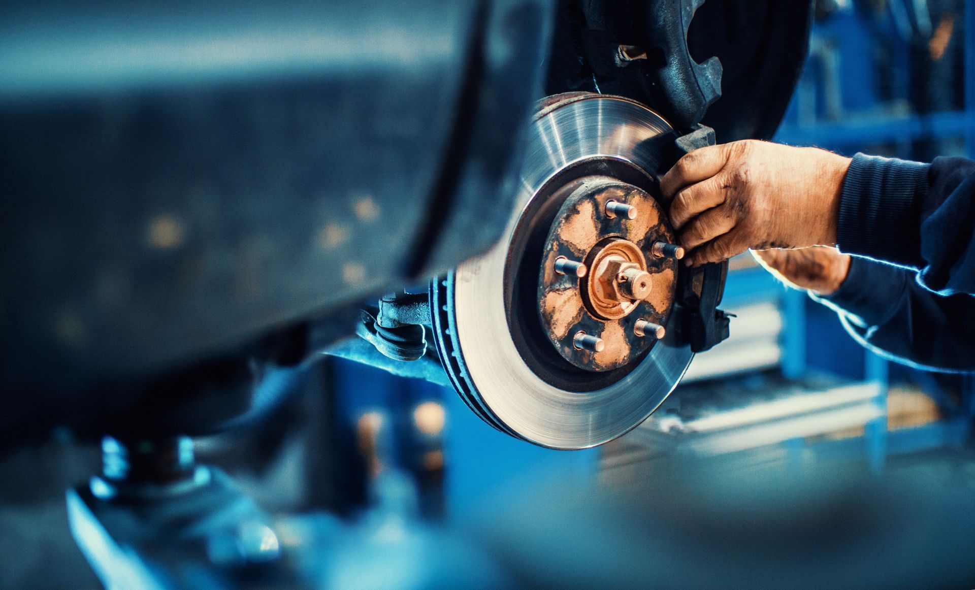 Closeup of a mechanic replacing car brake pads for car brake repair.