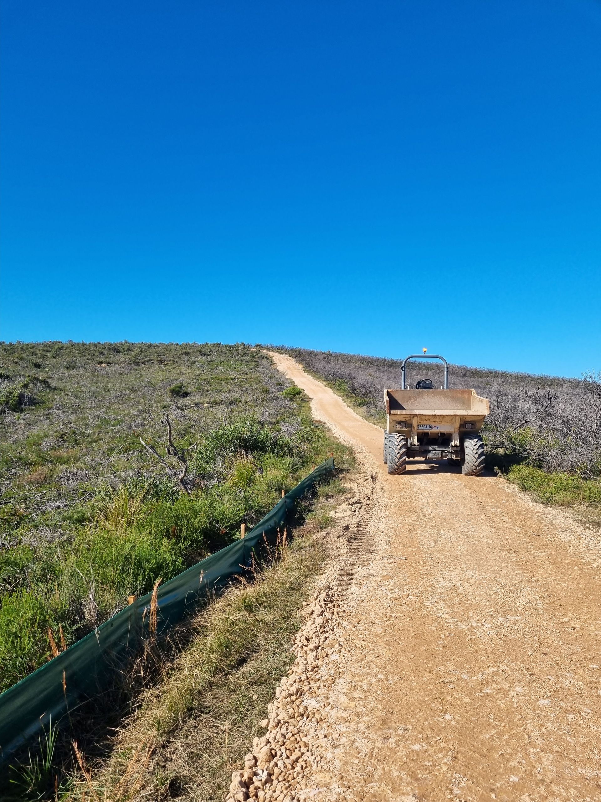 A tractor is driving down a dirt road. — Adam Lowe Earthmoving Pty Ltd in Somersby, NSW