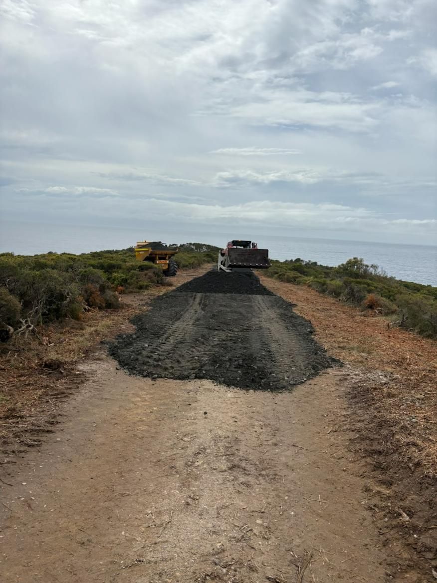 A Pile of Dirt Is Sitting on The Side of A Dirt Road — Adam Lowe Earthmoving Pty Ltd in Somersby, NSW