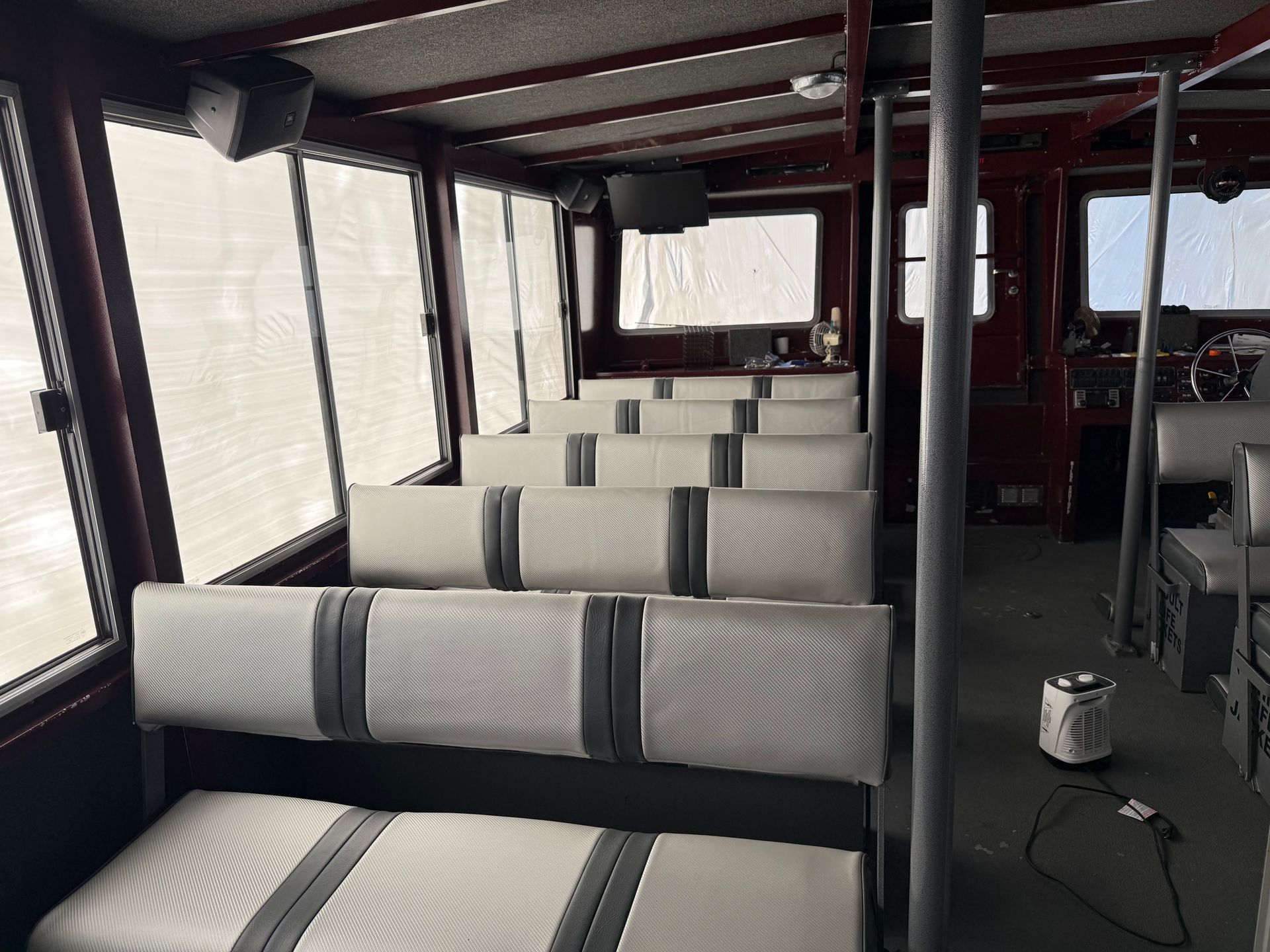 Rows of upholstered passenger seats in a vessel cabin