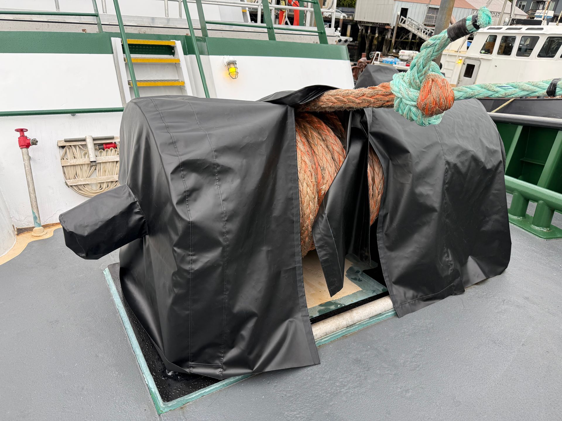 Dark fitted protective covers on working vessel equipment