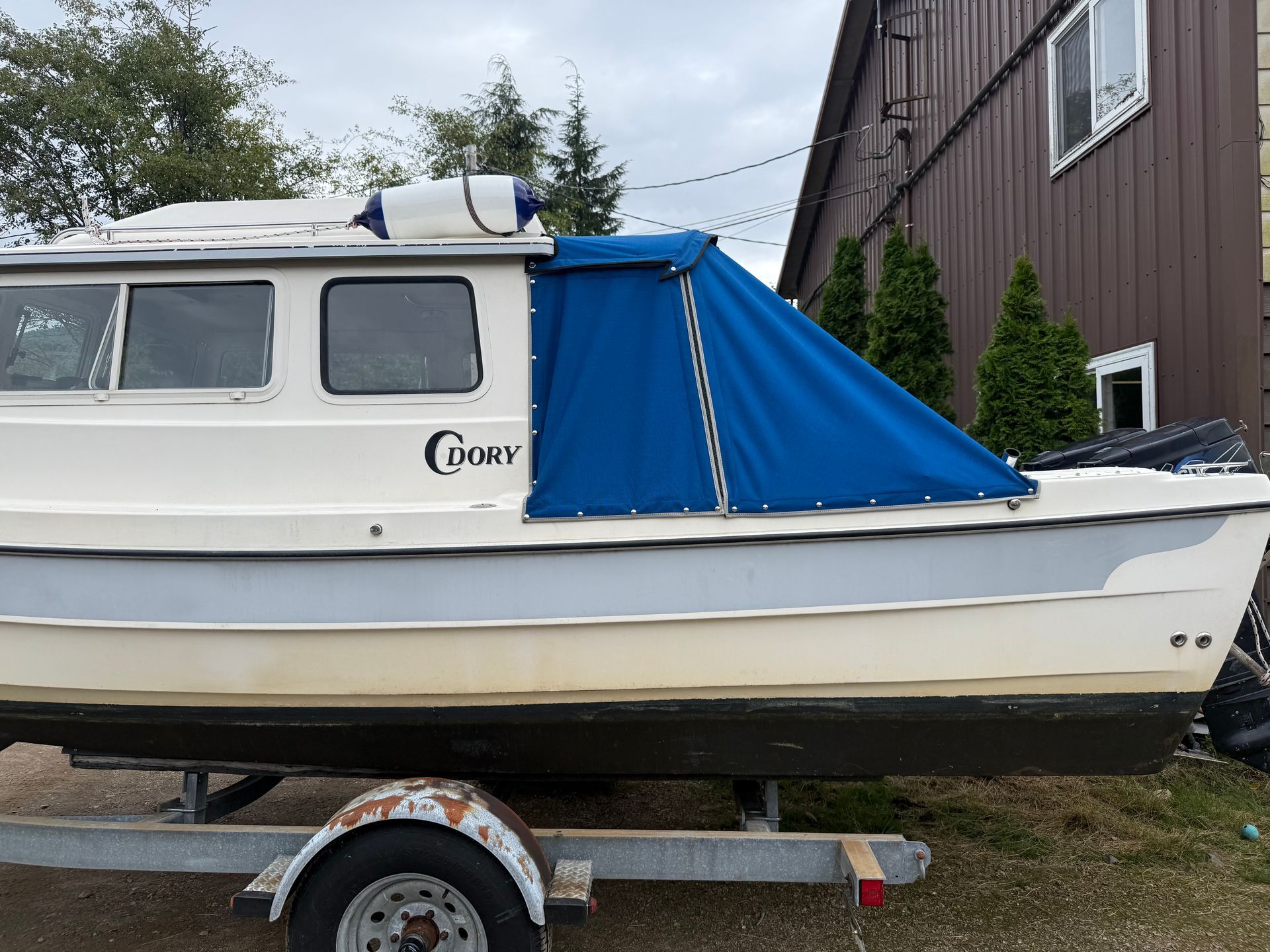 Blue fitted cockpit cover installed on a C-Dory boat