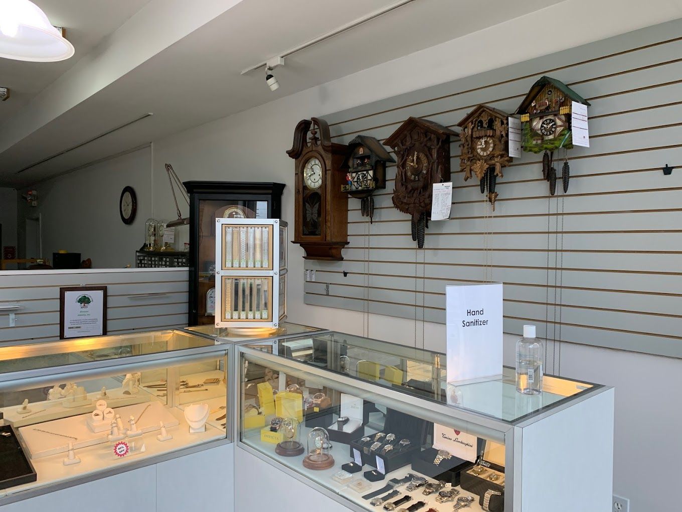 a display case filled with watches and cuckoo clocks in a store .