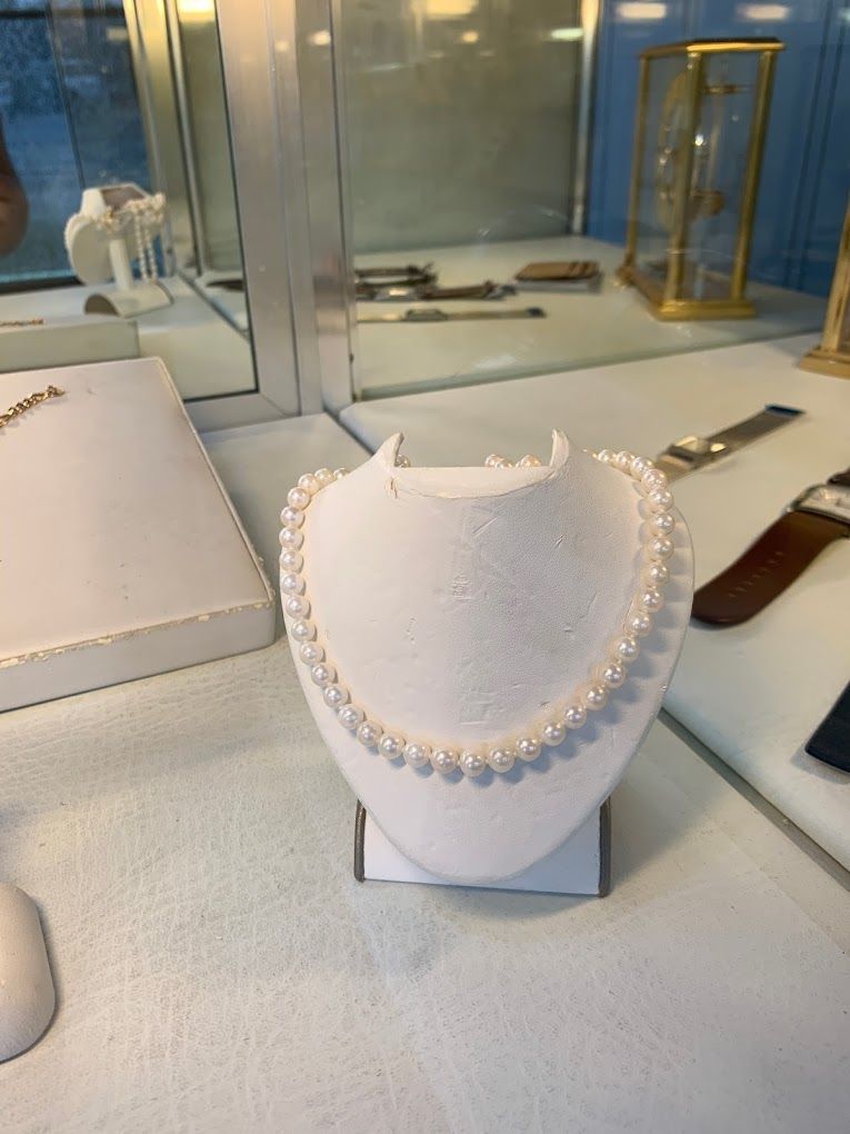 a white mannequin with a pearl necklace on it