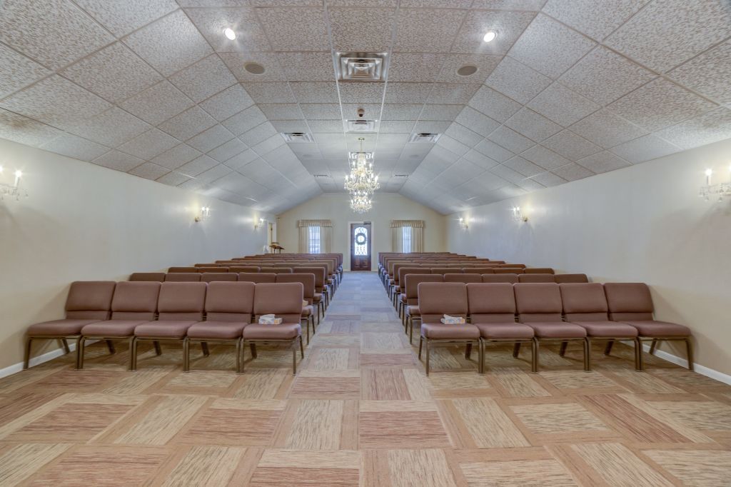 A large room with rows of chairs and a chandelier.