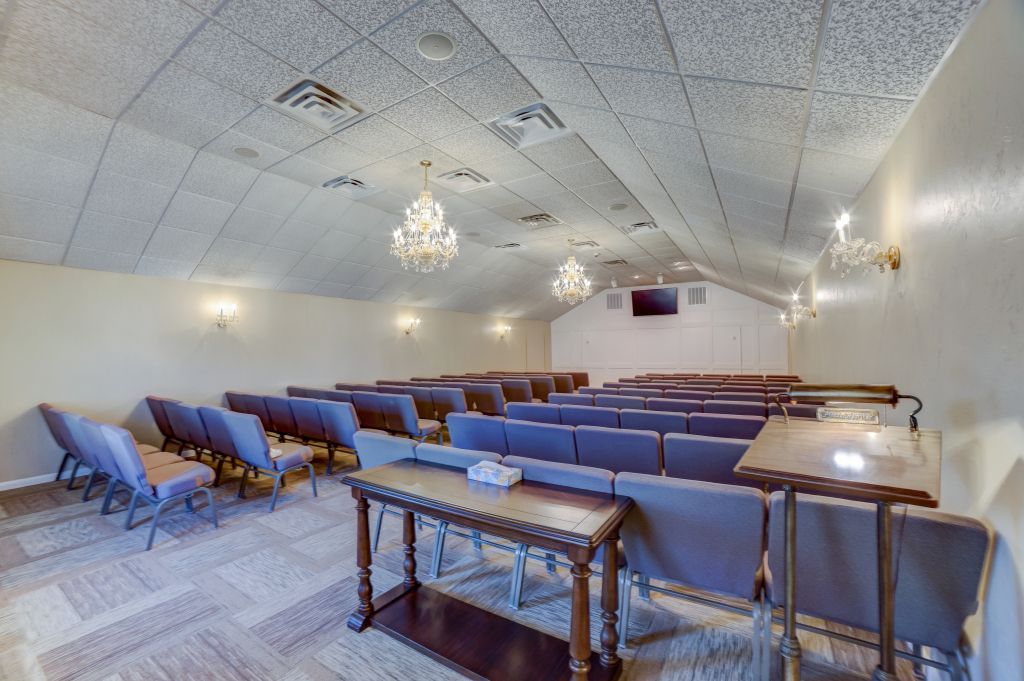 A large room with rows of chairs and a table in it.