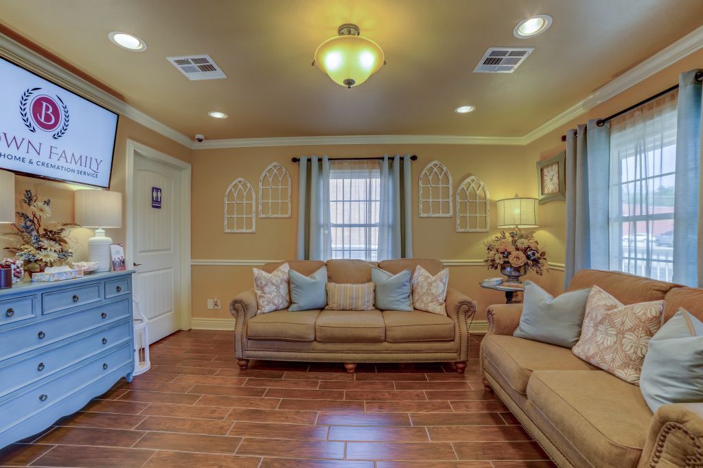 A living room with two couches , a dresser and a television.
