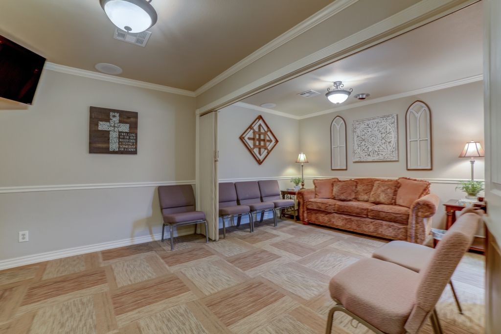 A living room with a couch , chairs and a television.