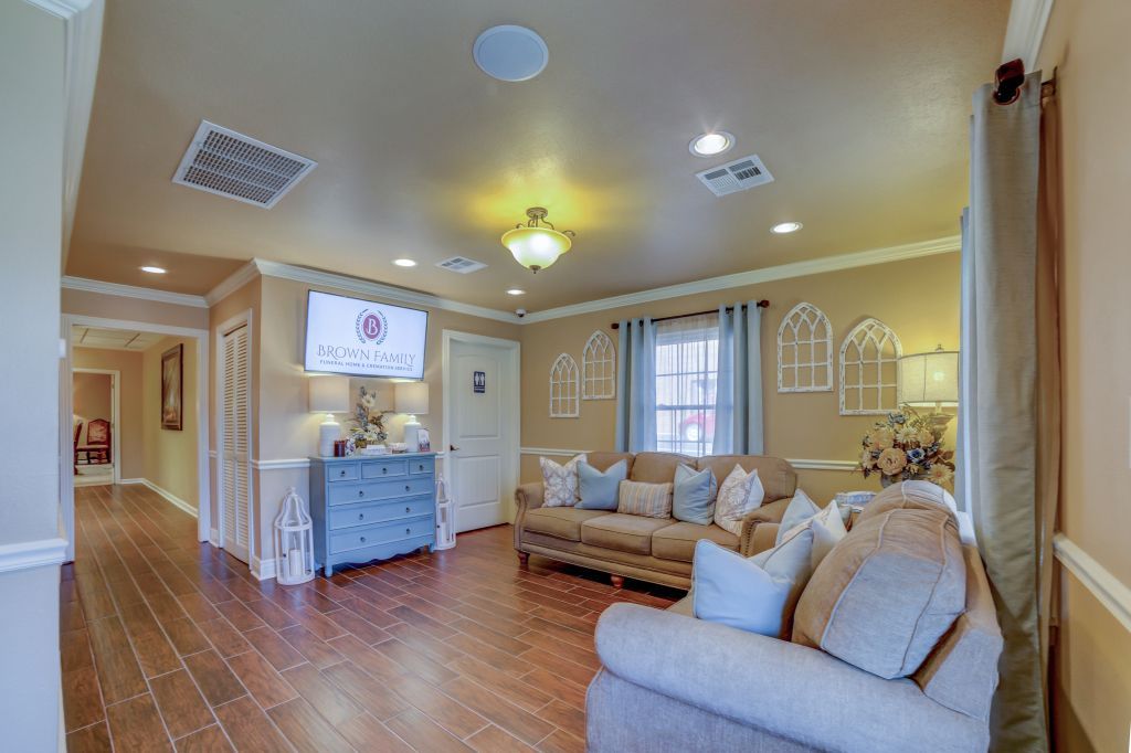 A living room with a couch , chair , and television.
