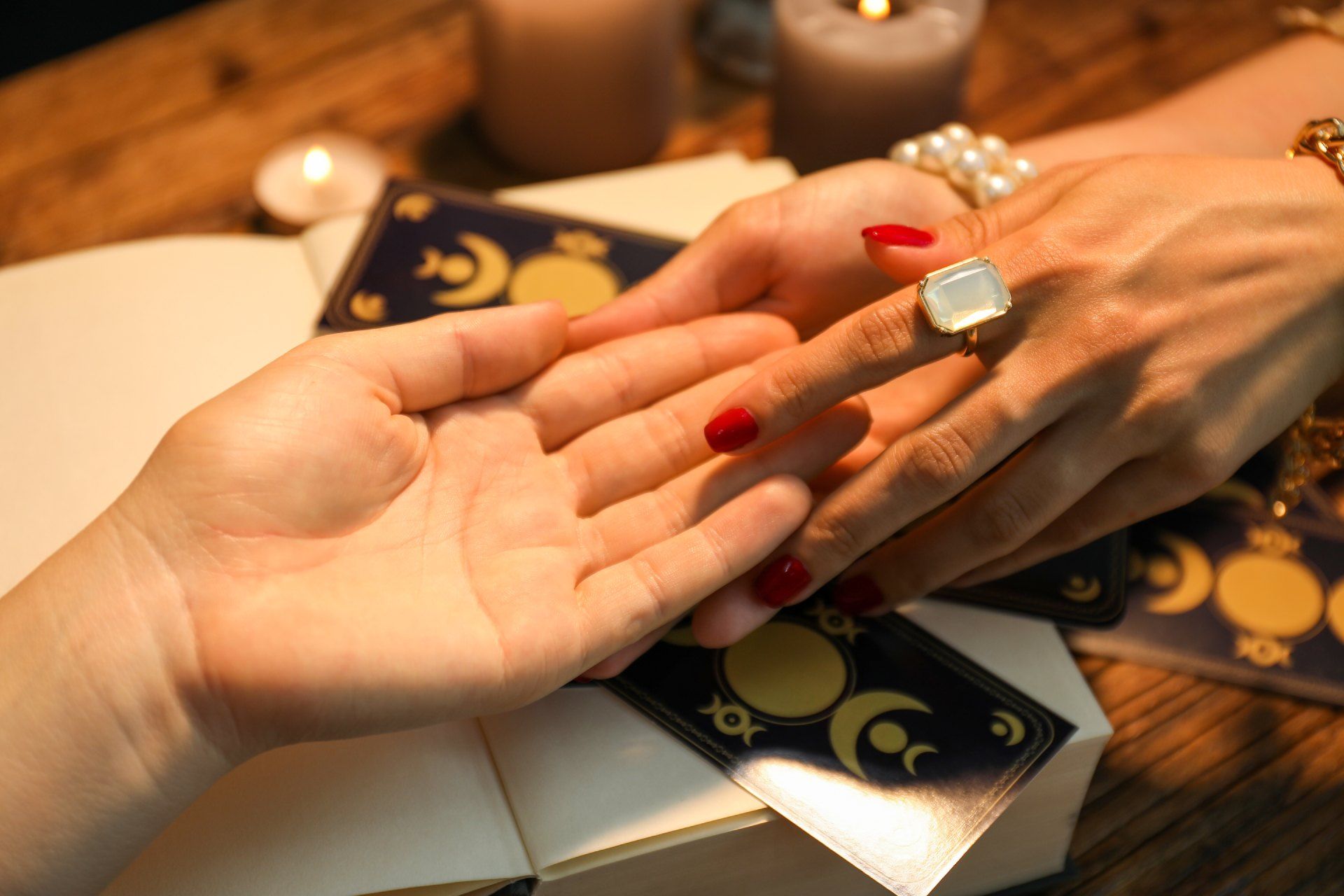 A woman is holding another woman 's hand and reading her palm.