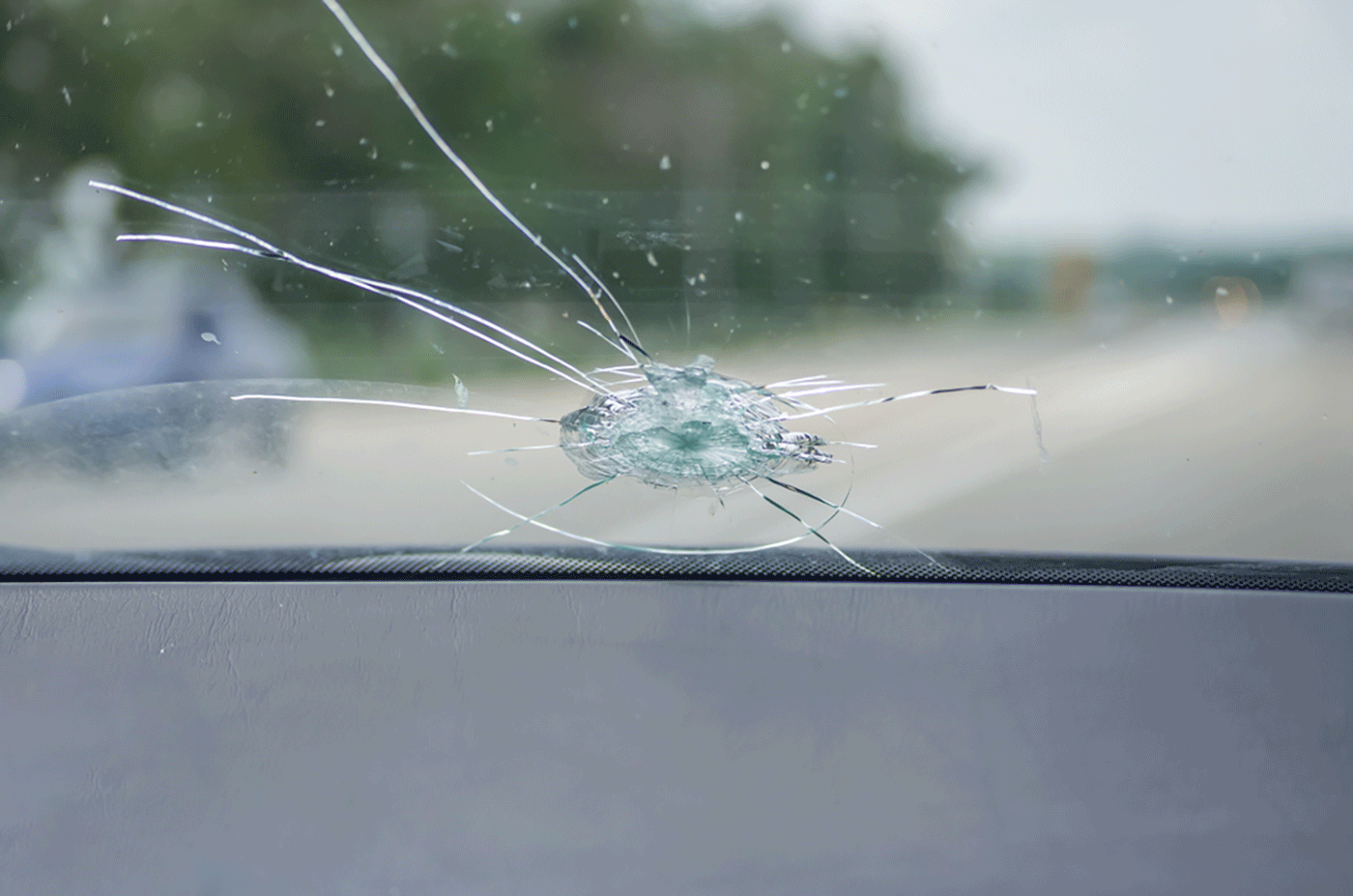 A close up of a broken windshield in a car.