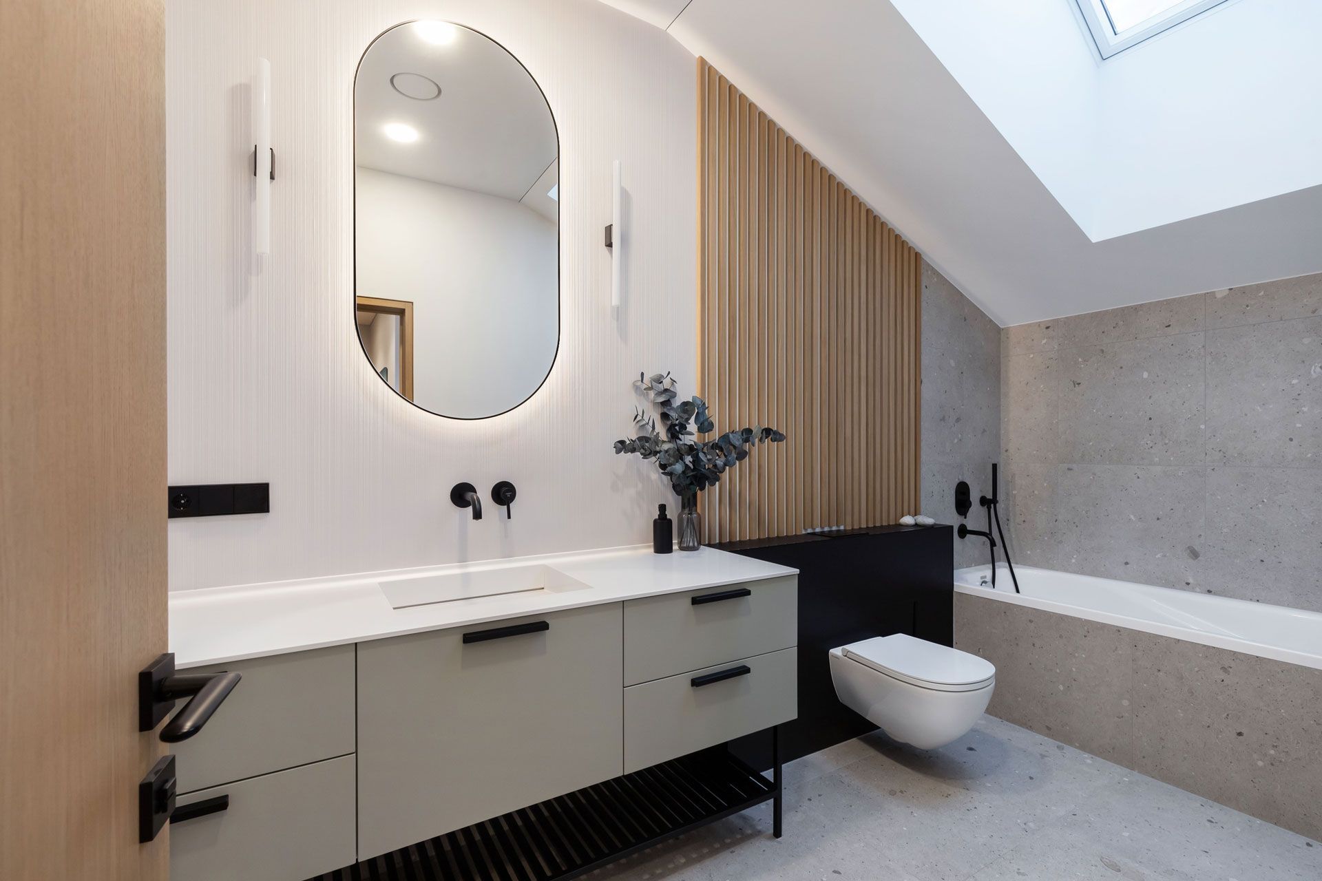 Modern bathroom with light green vanity, black fixtures, and wooden wall accents.
