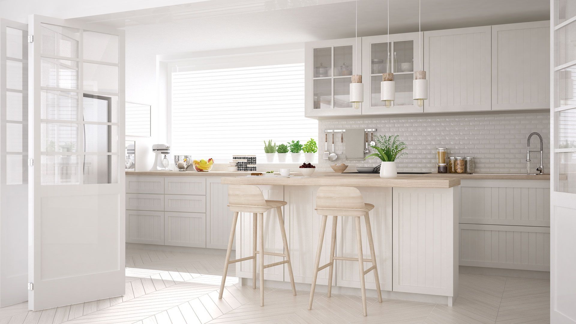 White kitchen with island and bar stools, white cabinetry, light wood countertops.