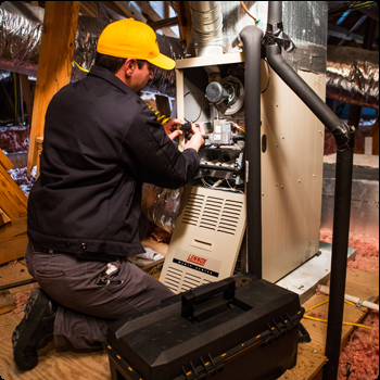 A man wearing a yellow hat is working on an air conditioner