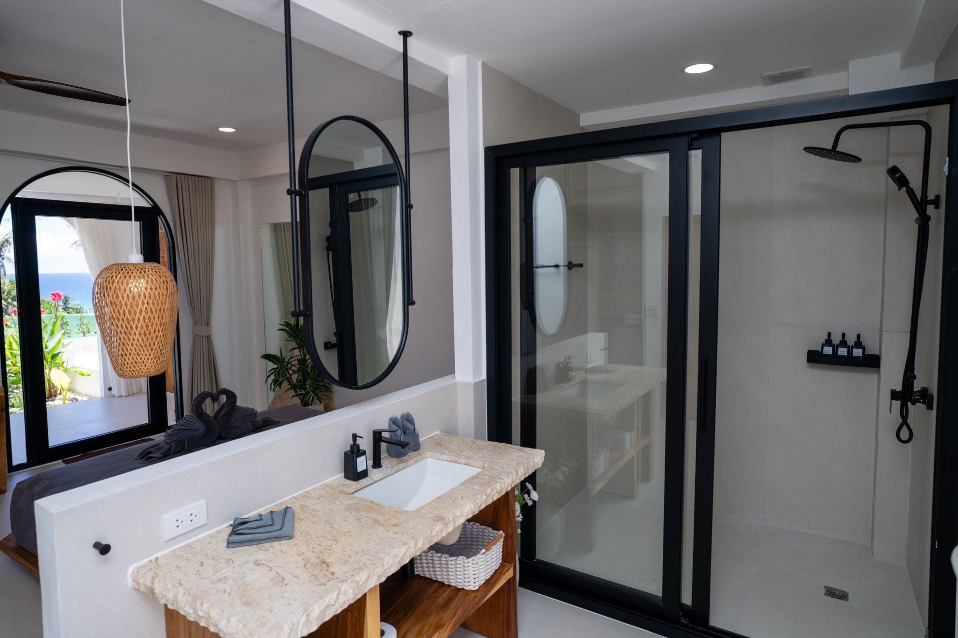 Modern bathroom with double sinks, large mirrors, and a glass-enclosed shower area