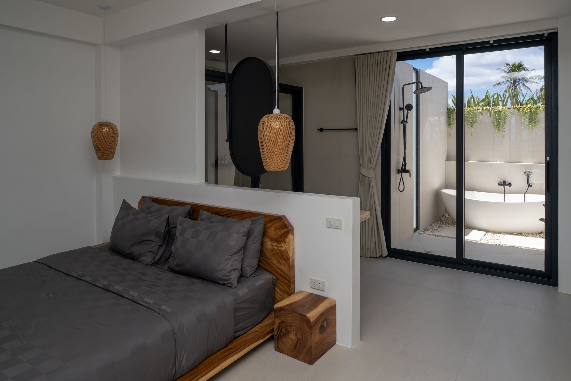 Modern bedroom with gray bed, wood accents, and sliding glass doors to a patio