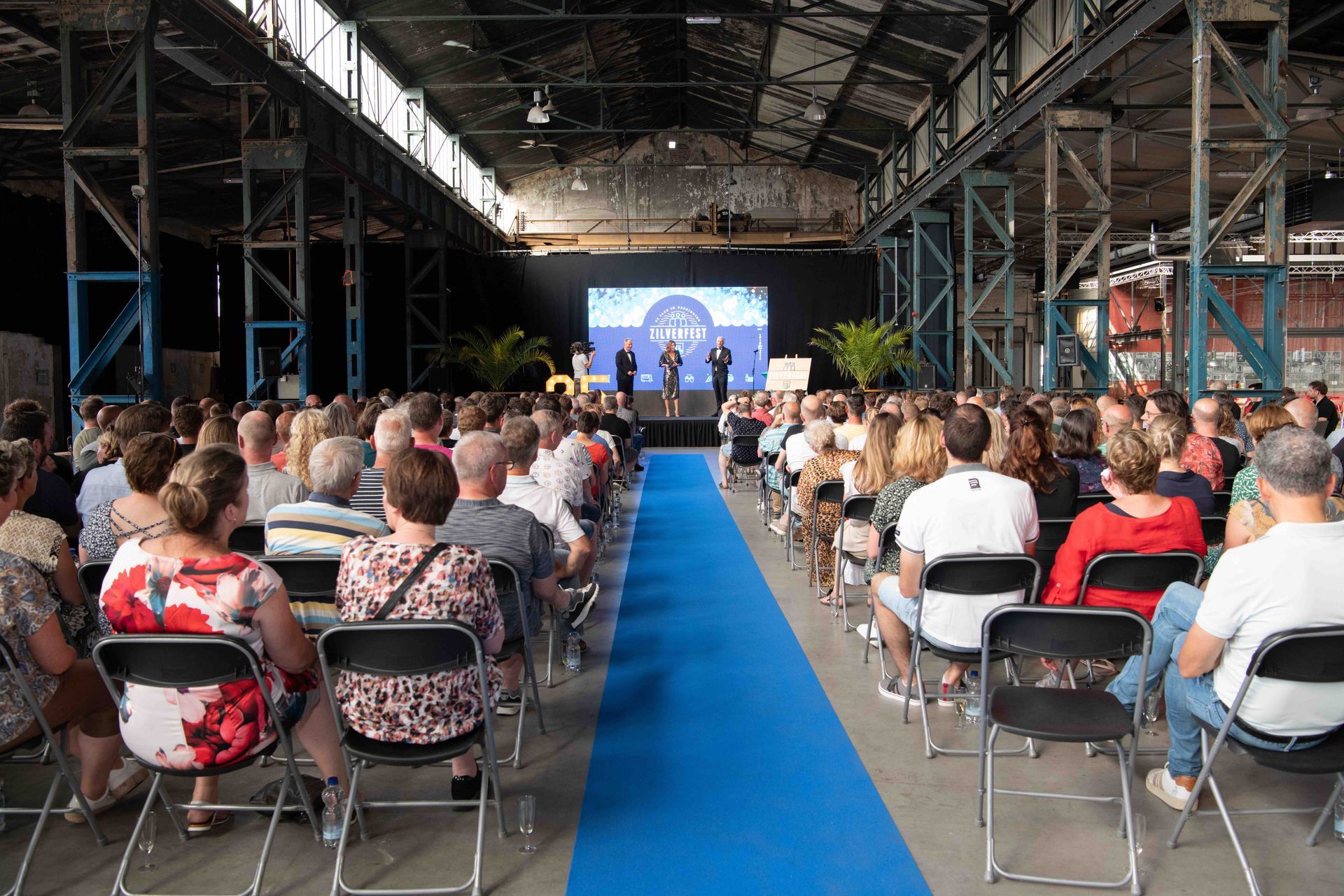 Sprekers presenteren tijdens de jubileumshow van Waterschap Rijn en IJssel, begeleid door Plan X Events.