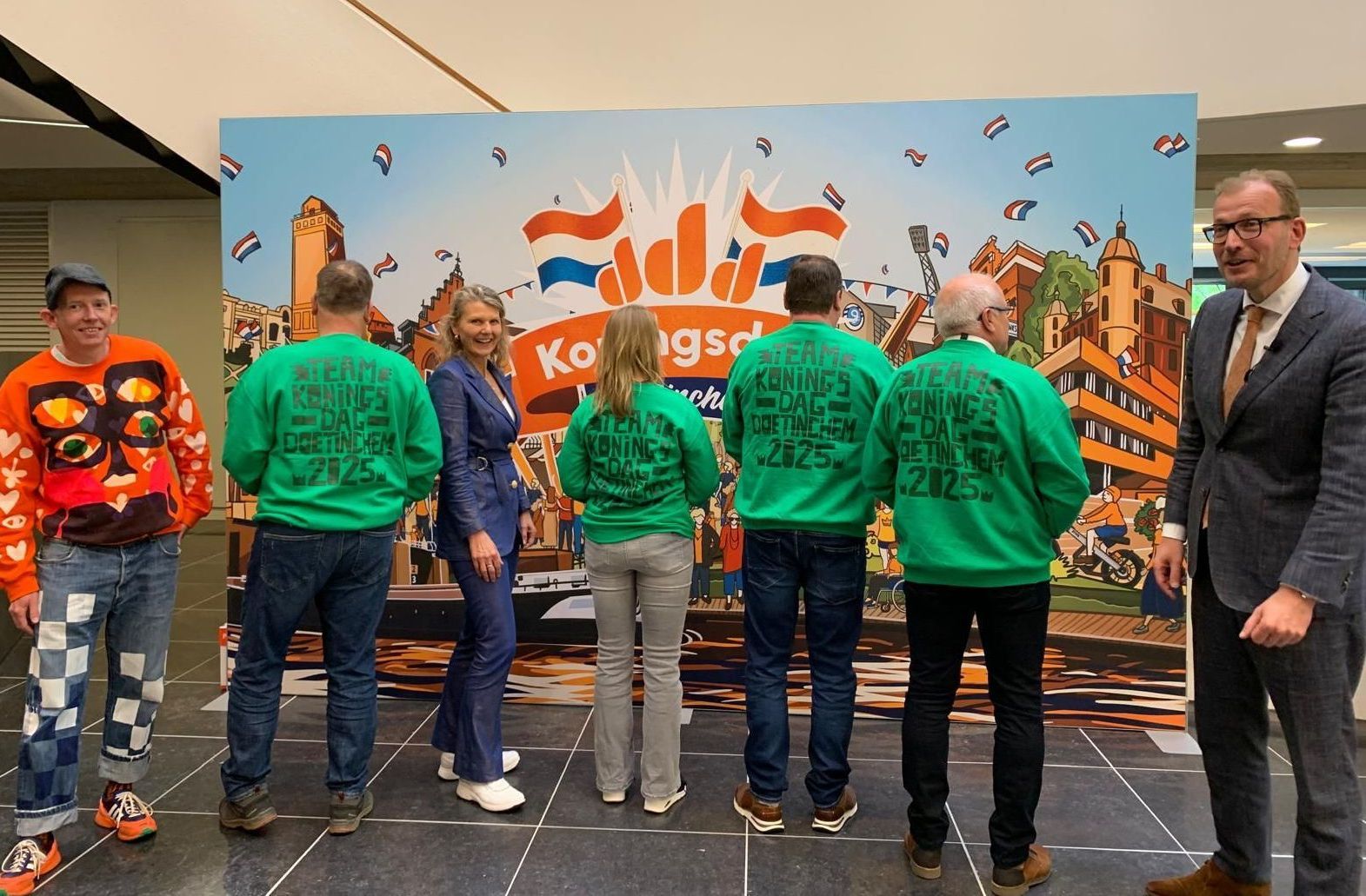 Burgemeester Bouman onthult de groene Koningsdag-vrijwilligerstruien in Doetinchem, georganiseerd door Plan X Events.
