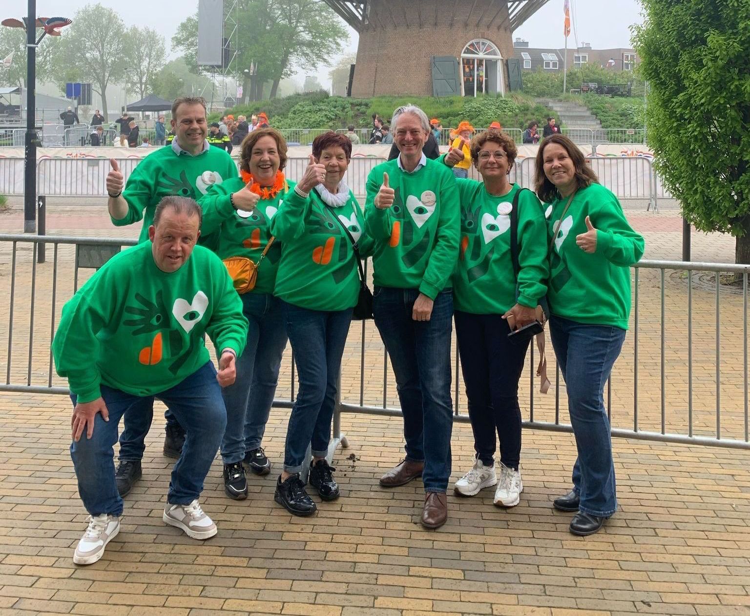 Een groep vrijwilligers is hun speciale groene sweaters voor Koningsdag in Doetinchem. 
