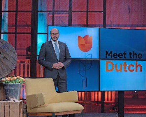 Man in pak voor een scherm met 