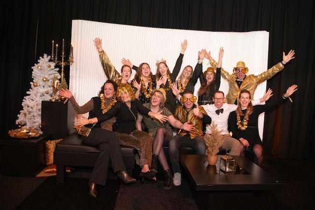 Medewerkers poseren in de fotobooth tijdens A Touch of Gold, georganiseerd door Plan X Events