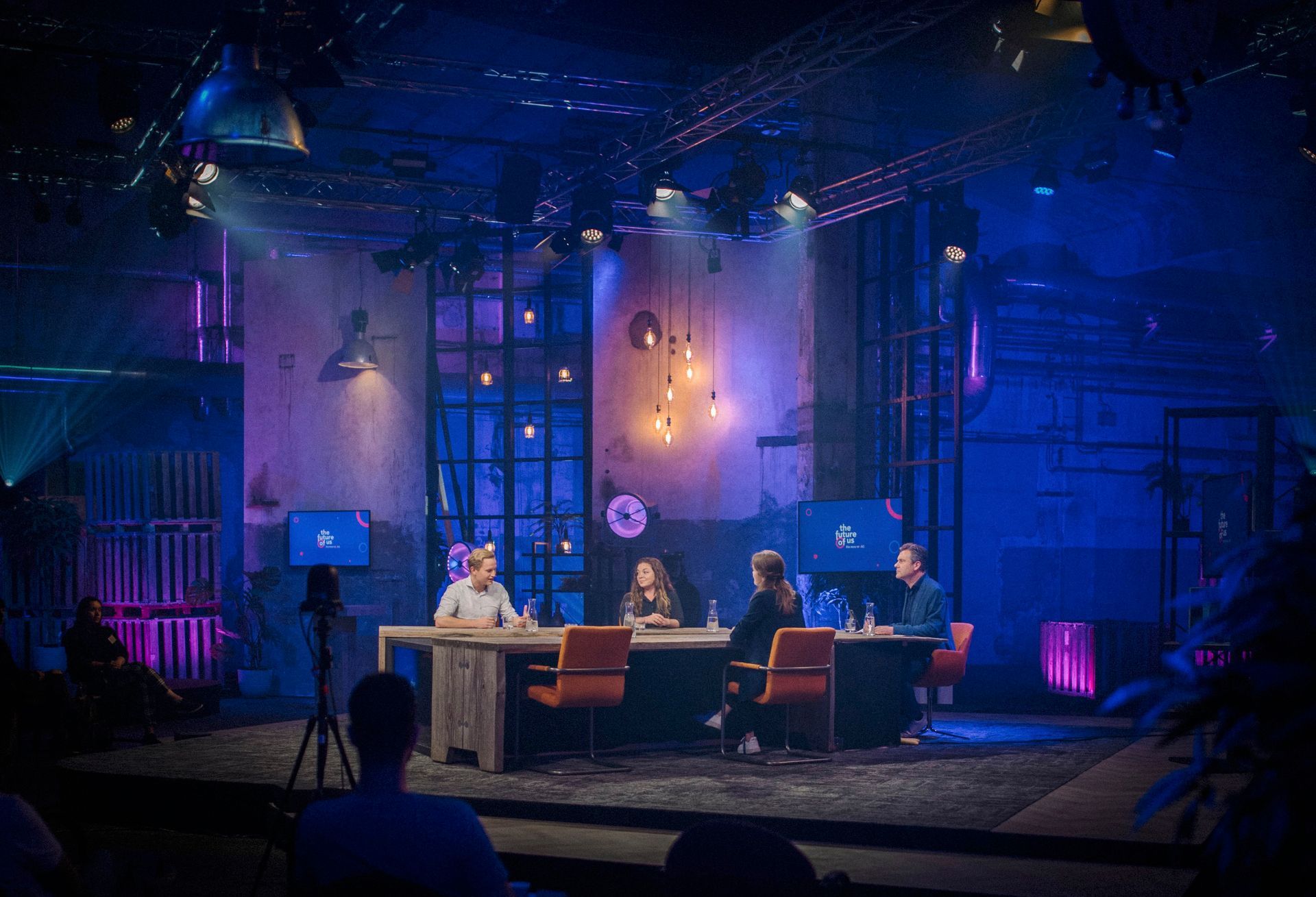 Sprekers en tafelgasten tijdens een live tafelgesprek op het podium van The Future of Us georganiseerd door Plan X Events.