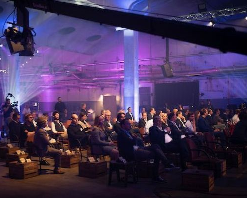 Publiek volgt interactieve sessies tijdens een kennisevent van Plan X Events