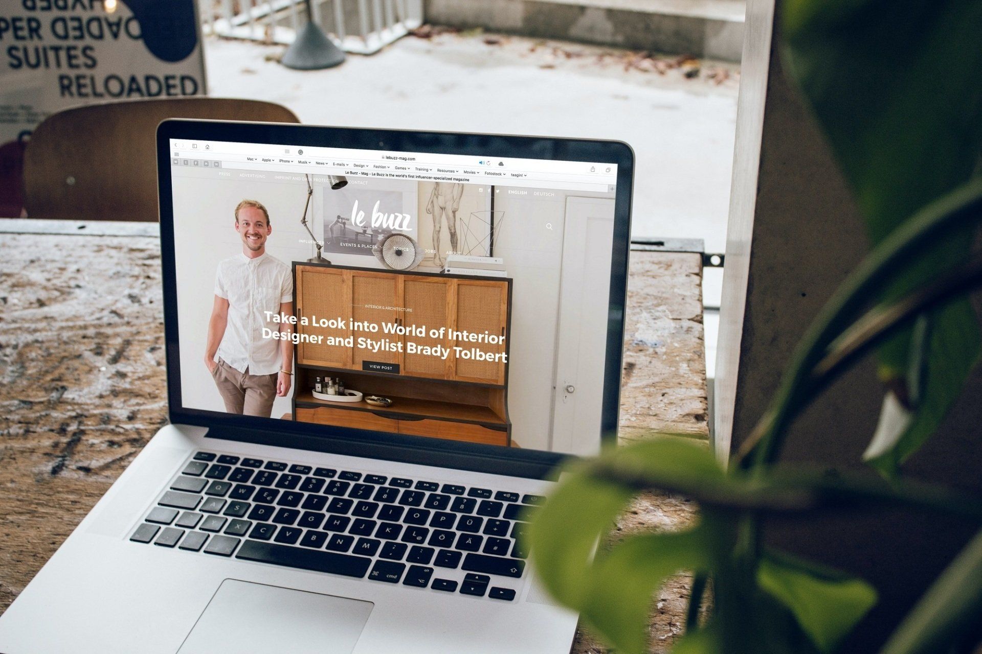 A laptop computer is open to a website with a picture of a man on the screen.