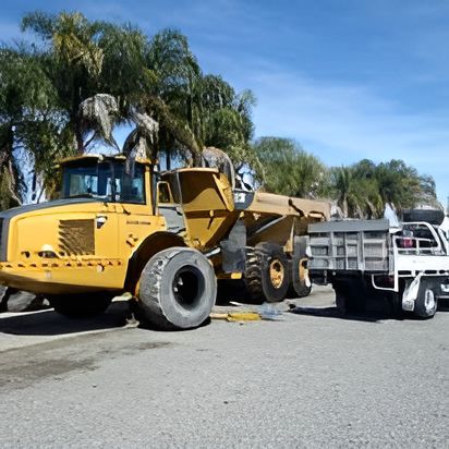A Yellow Dump Truck Is Parked Next To A White Truck — Clarence Valley Tyre Centre in South Grafton, NSW