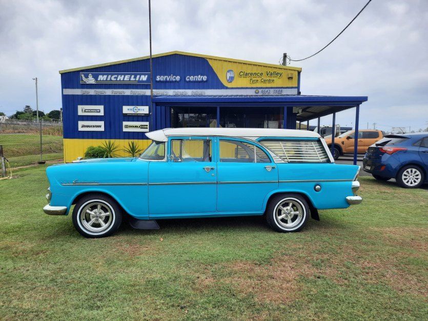 A Blue Car Is Parked In Front Of A Yellow And Blue Building — Clarence Valley Tyre Centre in South Grafton, NSW