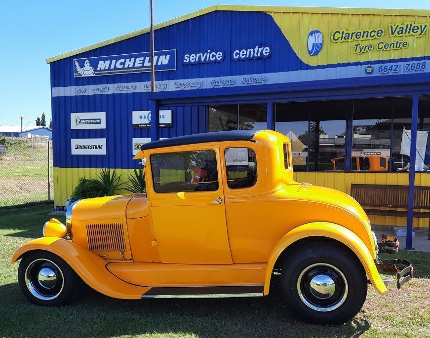 A Yellow Car Is Parked In Front Of A Michelin Service Centre — Clarence Valley Tyre Centre in South Grafton, NSW