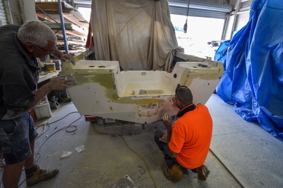 Two Men Are Working on a Boat in a Garage — Sandy Straits Marine In Urangan, QLD